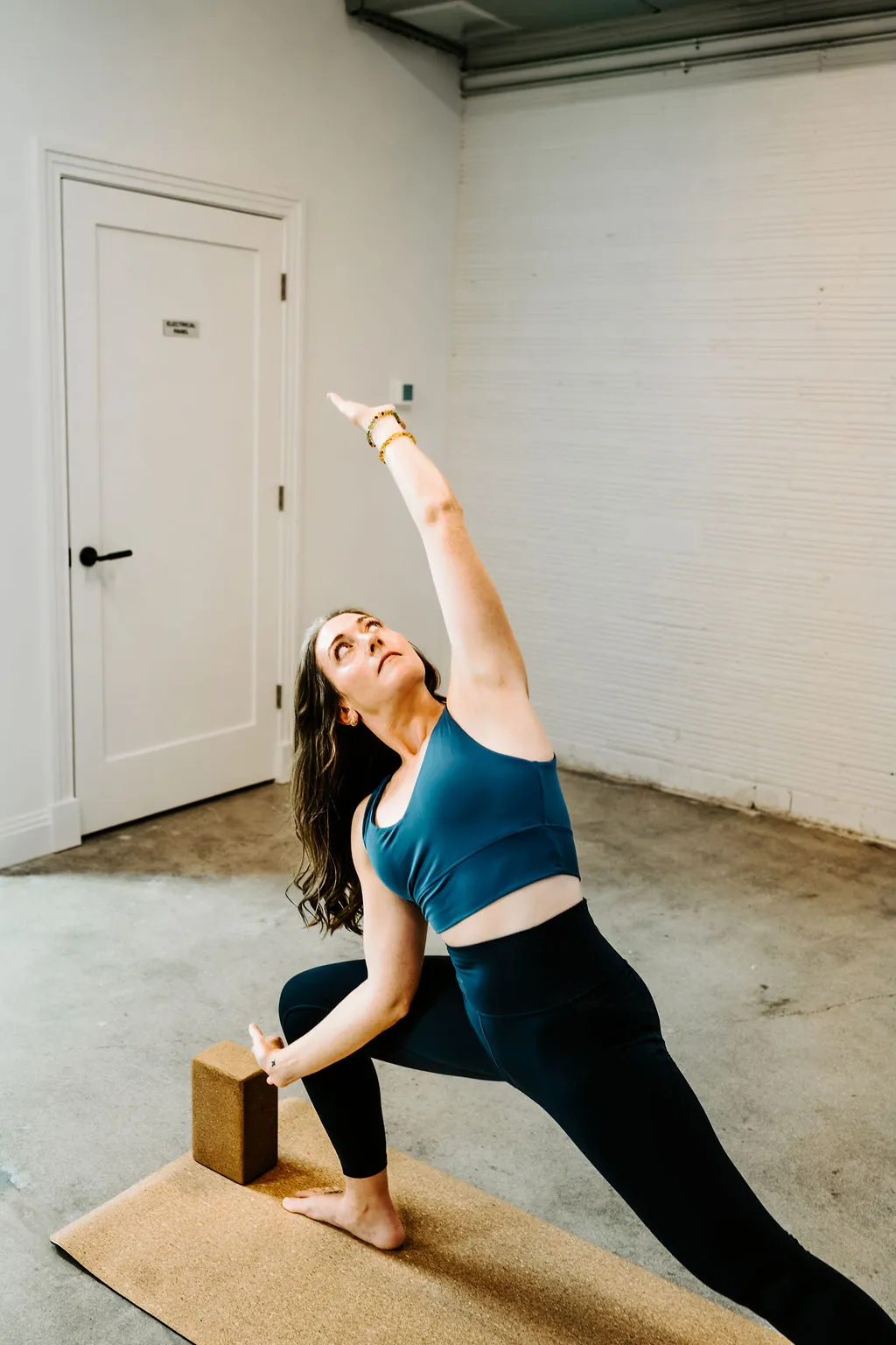 Paula guiding a side-angle stretch on a cork yoga mat